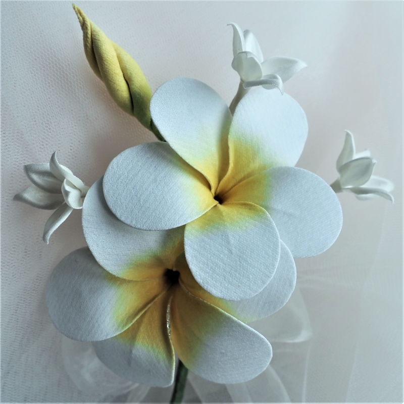 white fabric plumeria buttonhole